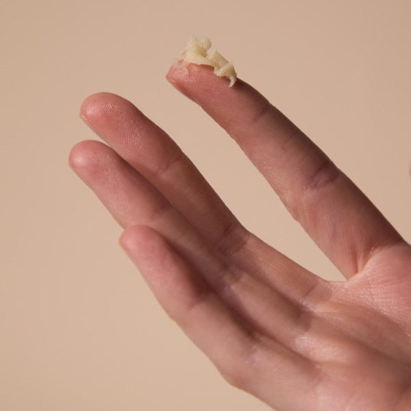 Hand holding a bit of cuticle balm for the File Manicure method