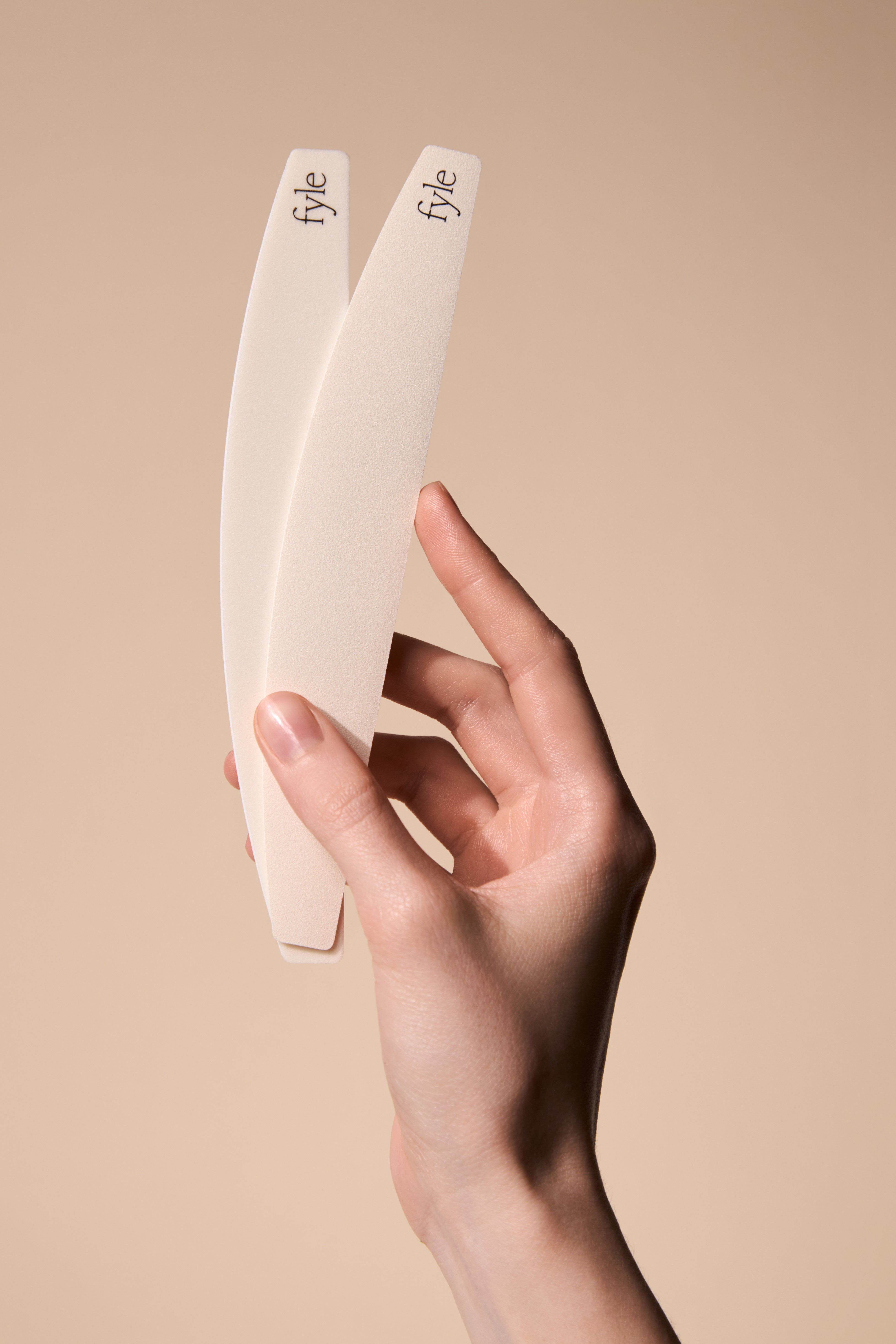Hand holding the Fyle File Manicure tools showing their clean, minimal design.
