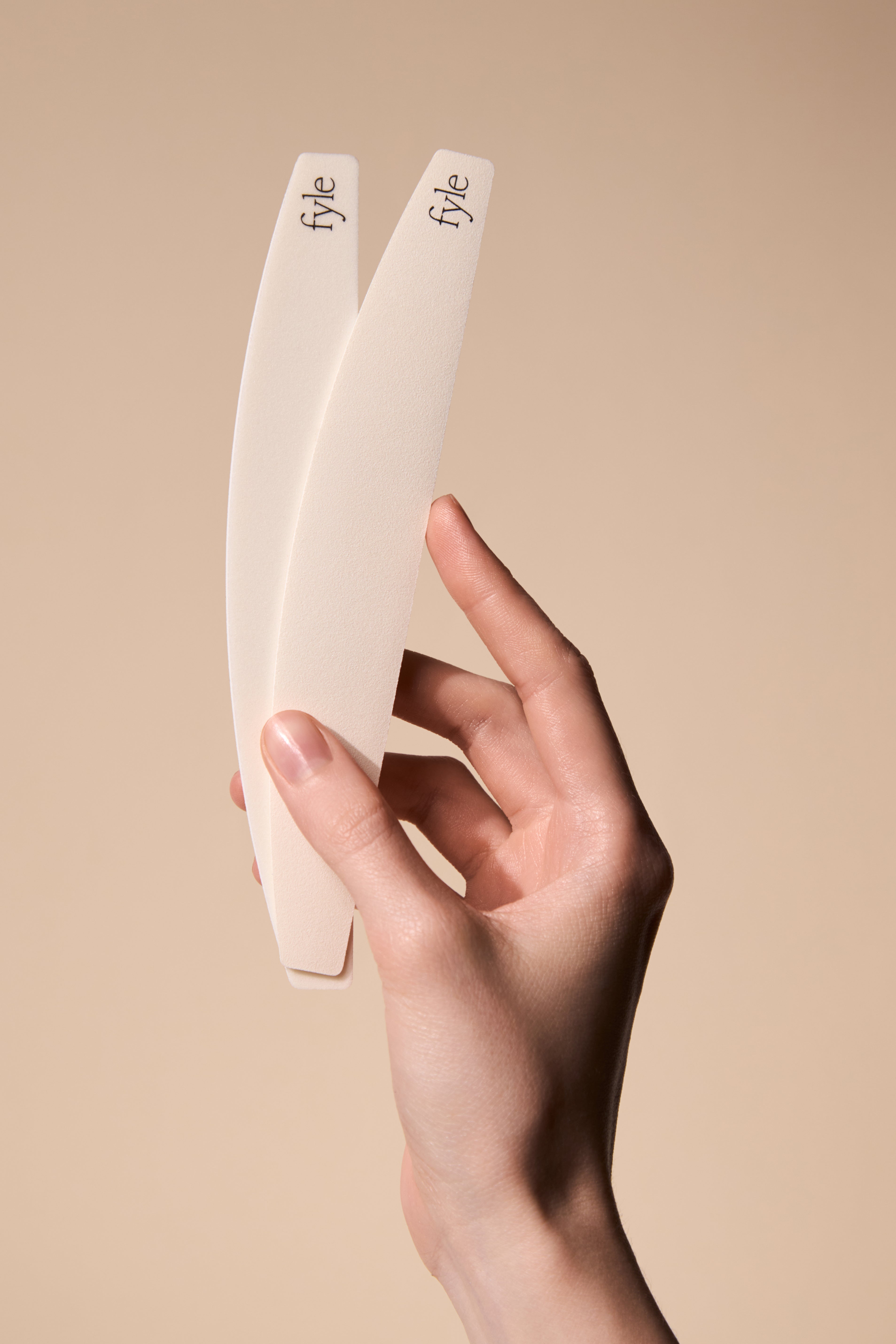 Hand holding the Fyle File Manicure tools showing their clean, minimal design.
