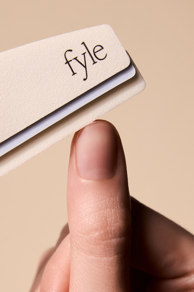 Close-up of a thumb being filed with Fyle nail file, promoting bare nails and cuticle care